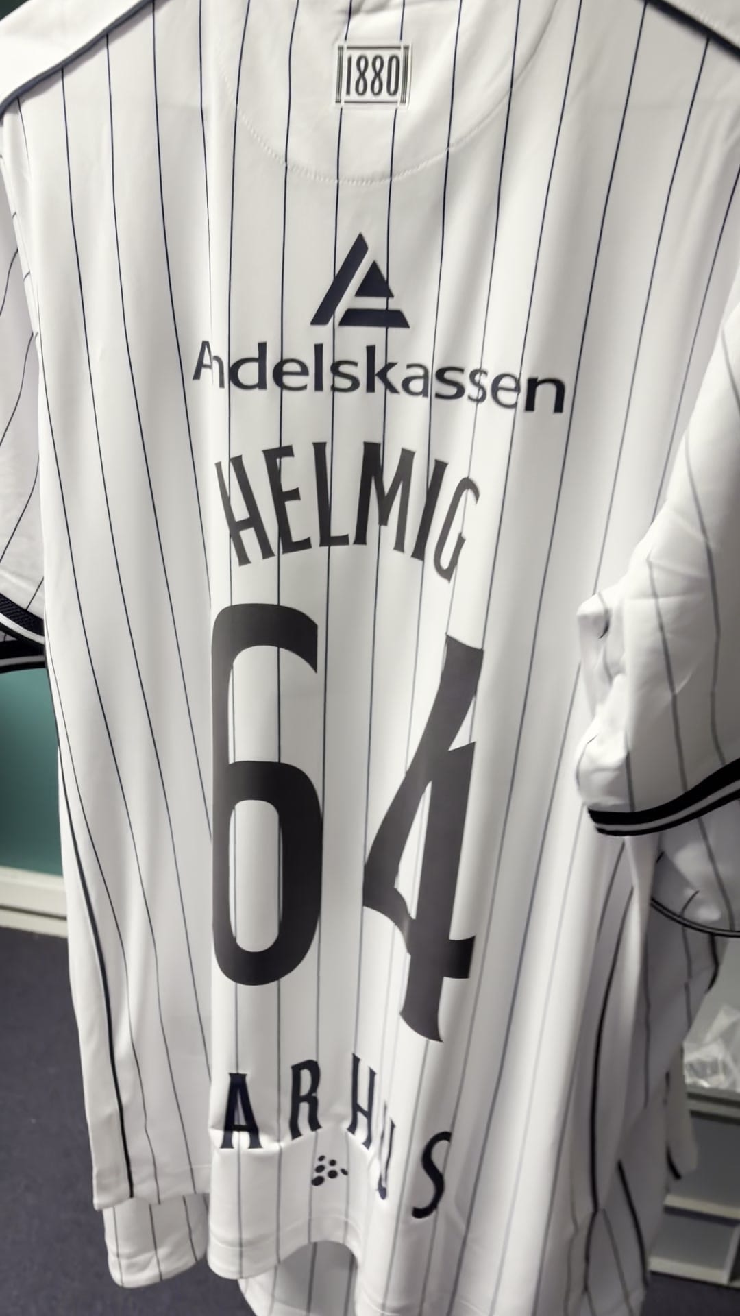 Nålestribet trøje med HELMIG og tallet 64 på ryggen