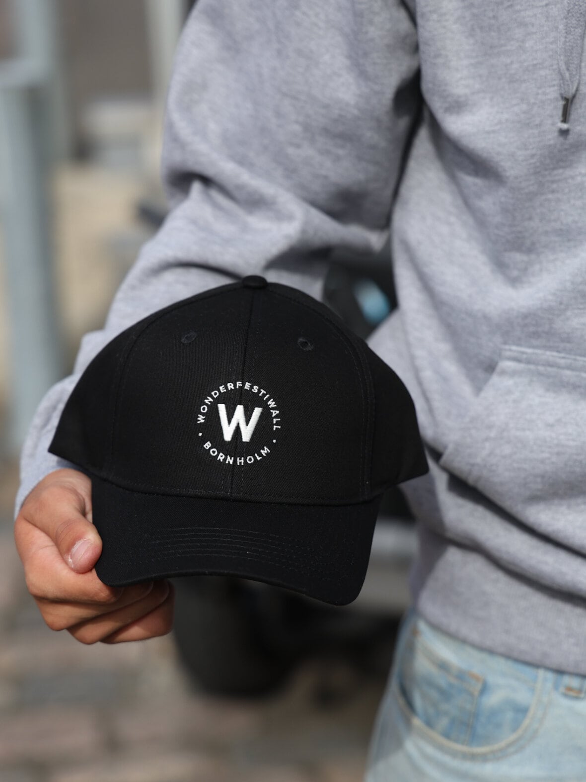 Sort cap med rundt Wonderfestiwall-mærke