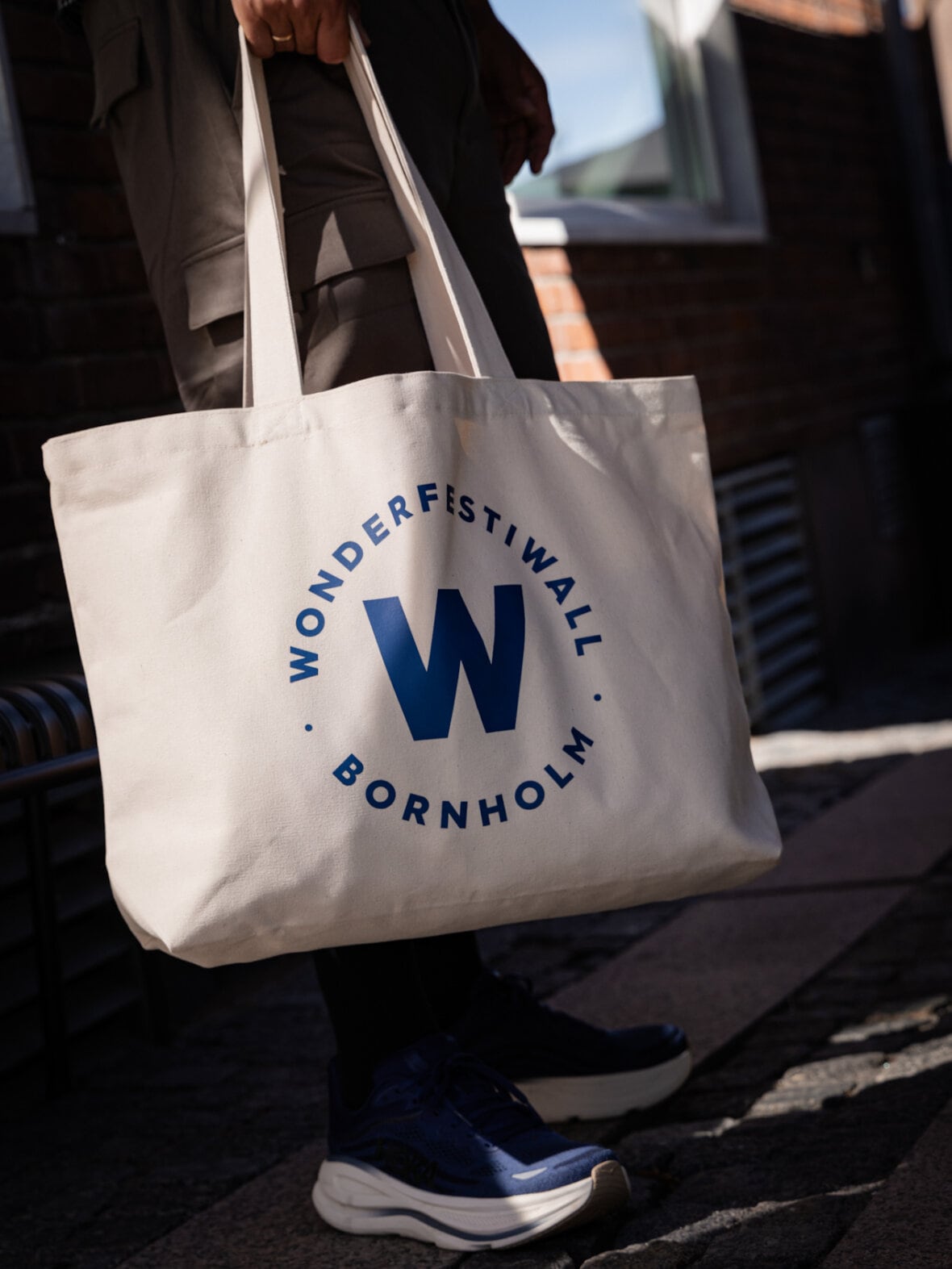 Wonderfestiwall-totebag båret i hånden